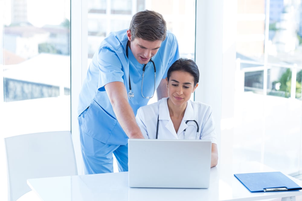 Team of doctors working on laptop in medical office
