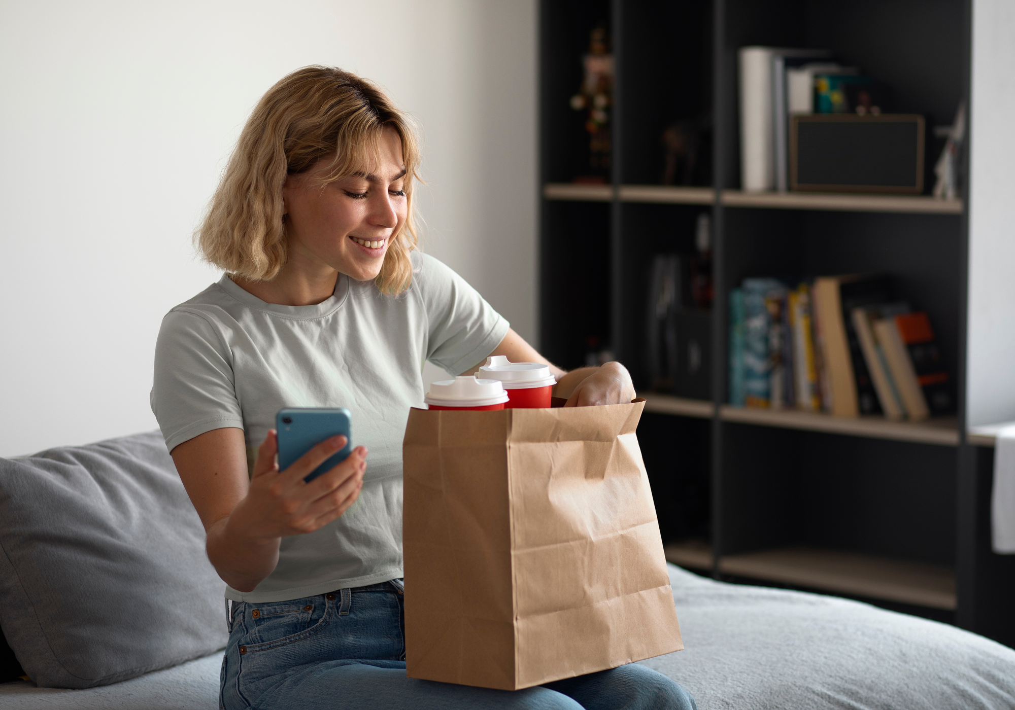 Woman opening up a paper bag with groceries.